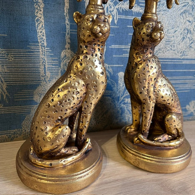 Front detail of the seated leopard figures with textured spots and antique gold finish