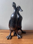 Bronze sculpture of two ducks on a wooden table