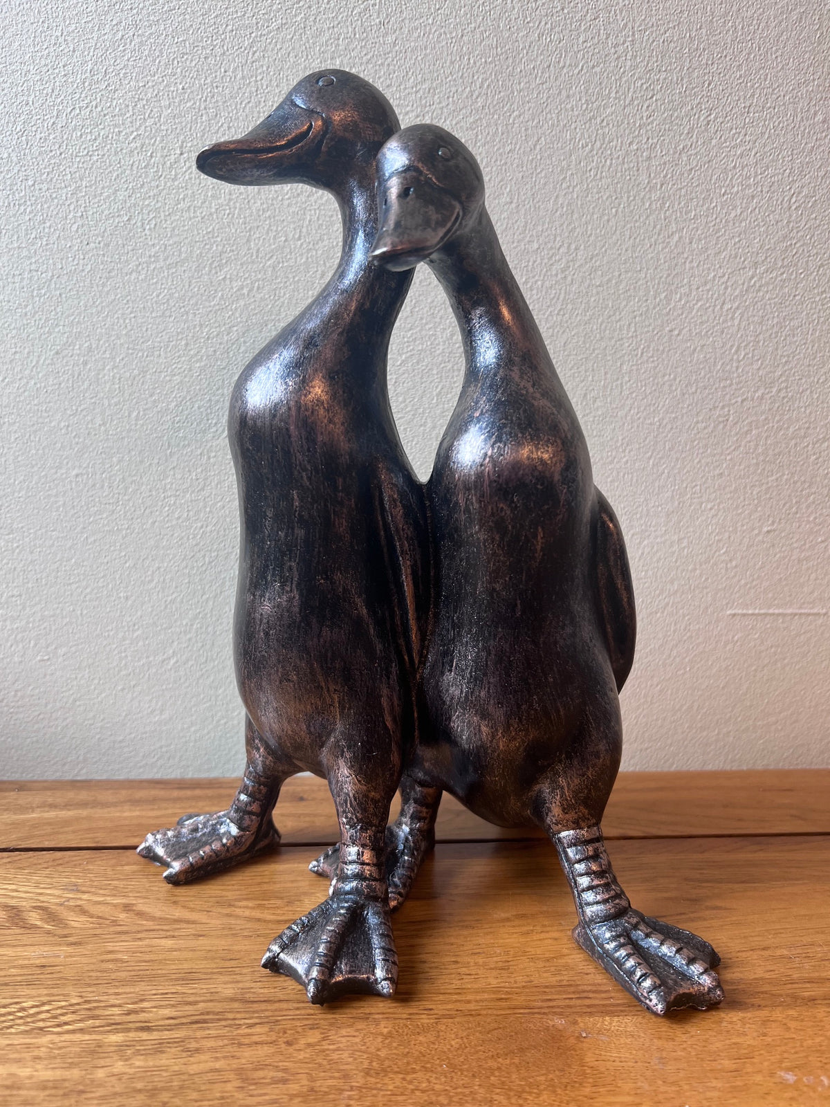 Decorative bronze effect companionship ducks sculpture on an oak table