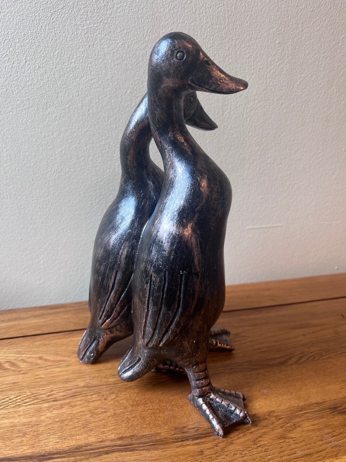 Bronze duck-shaped sculpture on a wooden surface