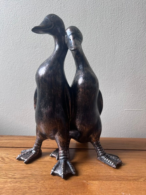 bronze ducks ornament on an oak top