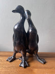 bronze ducks ornament on an oak top